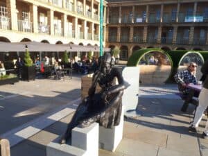 Anne Lister Statue at the Piece Hall. Behind are heated dining pods of the Trading Room restaurant.